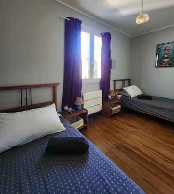 a bedroom with two beds and purple curtains at L'ECRIN DU LAC - Ô Cèpes in Mazamet
