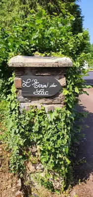 a sign on a stone wall with green plants at L'ECRIN DU LAC - Ô Cèpes in Mazamet
