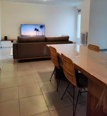 a living room with a table and a couch at L'Atelier Cosy in Lézignan-Corbières