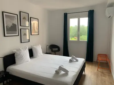 a living room with a couch and a large window at Appartement familial avec parking privatif in Carcassonne