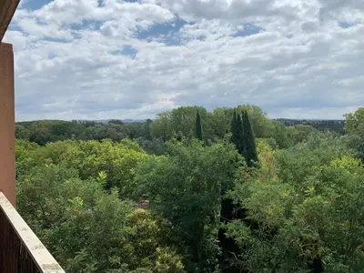 a balcony with chairs and a table and a view at Appartement familial avec parking privatif in Carcassonne