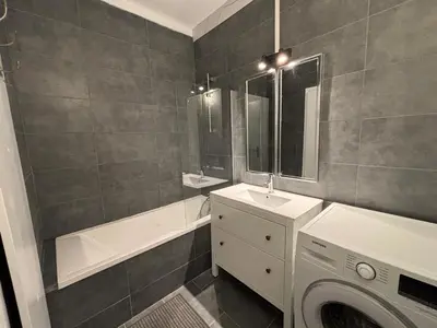 a bathroom with a washing machine and a washer at Appartement familial avec parking privatif in Carcassonne