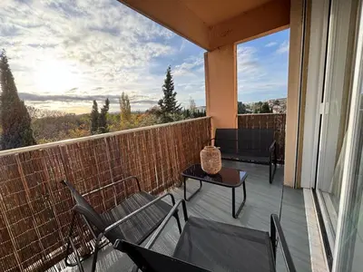 a balcony with chairs and a table and a view at Appartement familial avec parking privatif in Carcassonne