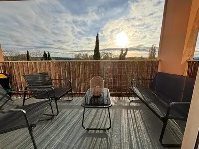 a living room with a couch and a large window at Appartement familial avec parking privatif in Carcassonne