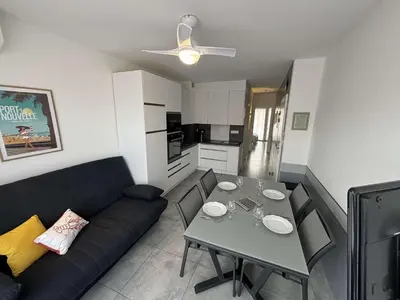 a living room with a black couch and a table at Appartement deux pièces Port la Nouvelle PN015-017 in Port-la-Nouvelle