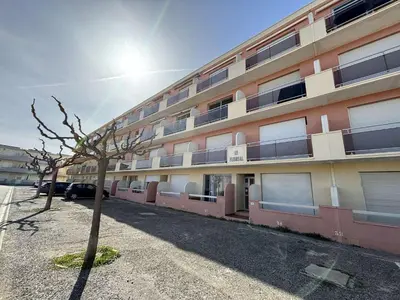 a building with a tree in front of it at Appartement deux pièces Port la Nouvelle PN015-017 in Port-la-Nouvelle