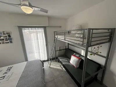 a bedroom with a bunk bed and a ladder at Appartement deux pièces Port la Nouvelle PN015-017 in Port-la-Nouvelle