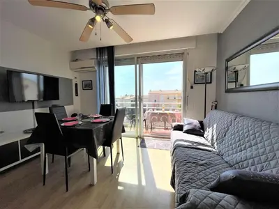 a living room with a couch and a table with chairs at Appartement deux pièces Port La Nouvelle PN020-031 in Port-la-Nouvelle