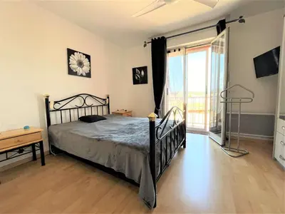 a bedroom with a bed and a large window at Appartement deux pièces Port La Nouvelle PN020-031 in Port-la-Nouvelle