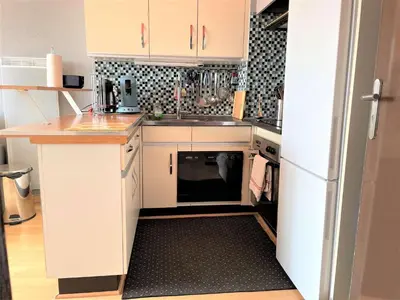 a kitchen with white cabinets and a white refrigerator at Appartement deux pièces Port La Nouvelle PN020-031 in Port-la-Nouvelle