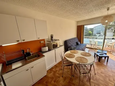 a kitchen with a table and a kitchen with a table and chairs at Studio 3 couchages PORT LA NOUVELLE PN040-004 in Port-la-Nouvelle