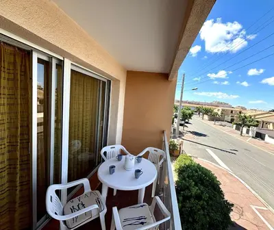 a balcony with a table and chairs and a street at Studio 3 couchages PORT LA NOUVELLE PN040-004 in Port-la-Nouvelle