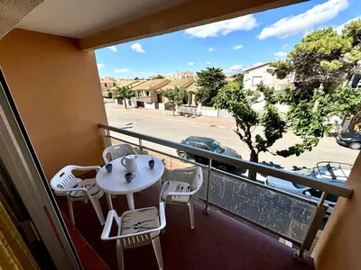 a balcony with a table and chairs and a view of a street at Studio 3 couchages PORT LA NOUVELLE PN040-004 in Port-la-Nouvelle
