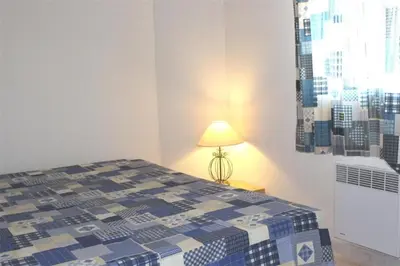 a bedroom with a bed with a lamp next to it at Pavillon dans résidence avec piscine Grazel GA090-056 in Gruissan