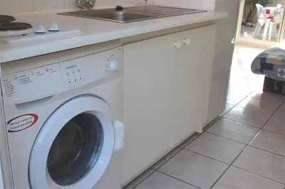 a washing machine in a kitchen with a sink at Pavillon dans résidence avec piscine Grazel GA090-056 in Gruissan