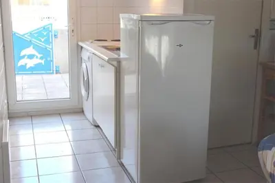 a white refrigerator in a kitchen next to a dishwasher at Pavillon dans résidence avec piscine Grazel GA090-056 in Gruissan