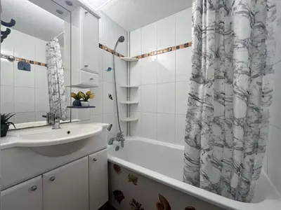 a bathroom with a sink and a shower curtain at Maison 2 pièces cabine - Gruissan GN020-084 in Gruissan