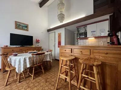 a kitchen with a table with chairs and a television at Maison 2 pièces cabine - Gruissan GN020-084 in Gruissan