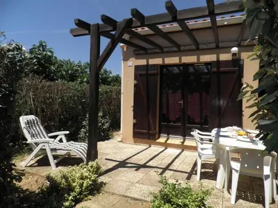 a patio with a table and chairs and a pergola at Maison 2 pièces cabine - Gruissan GN020-084 in Gruissan