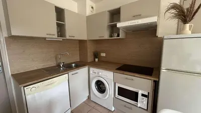 a kitchen with a white refrigerator and a washer and dryer at Appartement 2 pièces climatisé proche du port GN190-015 in Gruissan