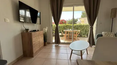 a living room with a television and a table at Appartement 2 pièces climatisé proche du port GN190-015 in Gruissan