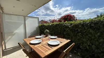 a wooden table with plates and glasses on a patio at Appartement 2 pièces climatisé proche du port GN190-015 in Gruissan