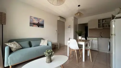 a living room with a blue couch and a table at Appartement 2 pièces climatisé proche du port GN190-015 in Gruissan