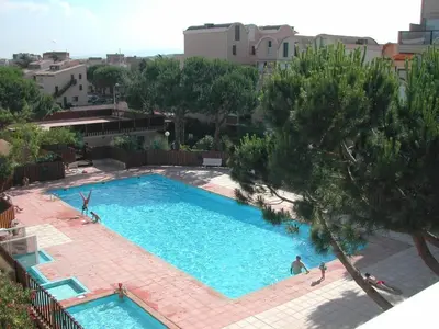 a large blue swimming pool with people in it at Appartement dernier étage avec terrasse vue port GN400-028 in Gruissan