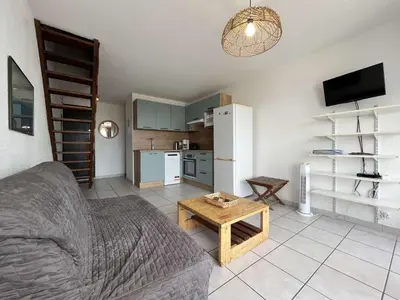 a living room with a couch and a table at Appartement dernier étage avec terrasse vue port GN400-028 in Gruissan