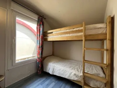 a bunk bed in a room with a window at Appartement dernier étage avec terrasse vue port GN400-028 in Gruissan