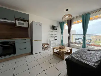 a room with a kitchen and a living room at Appartement dernier étage avec terrasse vue port GN400-028 in Gruissan