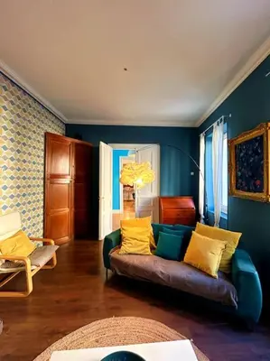 a living room with a couch with yellow pillows at La Maison Cardau in Névian