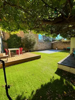 a garden with a table and chairs on a deck at La Maison Cardau in Névian
