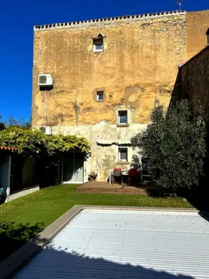 a large brick building with a courtyard in front of it at La Maison Cardau in Névian