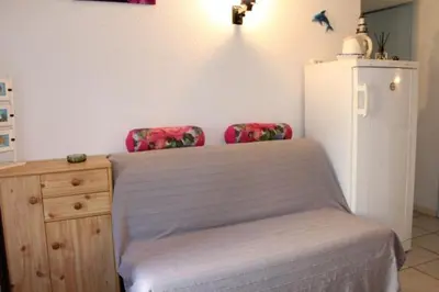 a bedroom with a bed with two chairs and a refrigerator at Appartement avec parking privé proche de la plage GN250-089 in Gruissan