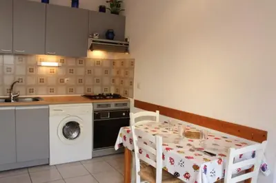 a kitchen with a table and a washing machine at Appartement avec parking privé proche de la plage GN250-089 in Gruissan