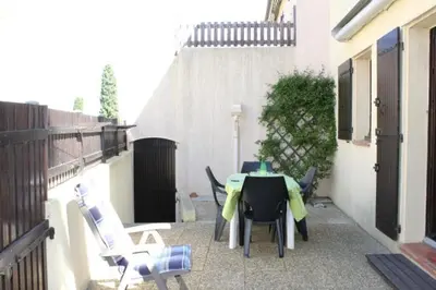a patio with a table and chairs on a balcony at Appartement avec parking privé proche de la plage GN250-089 in Gruissan