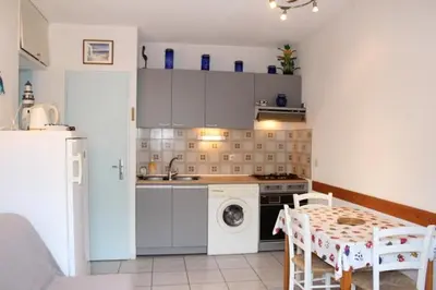 a kitchen with a stove and a washing machine at Appartement avec parking privé proche de la plage GN250-089 in Gruissan