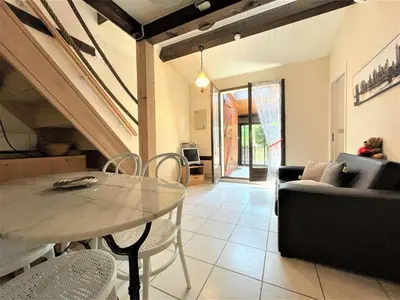 a living room with a table and a couch at Petit pavillon climatisé avec parking privé Grazel GN490-055 in Gruissan