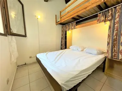 a bedroom with a bed with white sheets and pillows at Petit pavillon climatisé avec parking privé Grazel GN490-055 in Gruissan