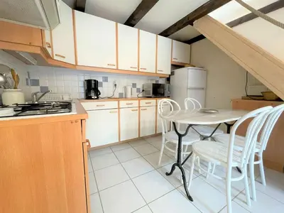 a kitchen with a table and chairs and a refrigerator at Petit pavillon climatisé avec parking privé Grazel GN490-055 in Gruissan