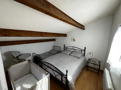 a bedroom with a black bed and a window at Maison de vacances à la mer in Port-la-Nouvelle