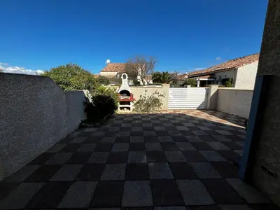 a driveway with a checkered floor in front of a house at Maison de vacances à la mer in Port-la-Nouvelle