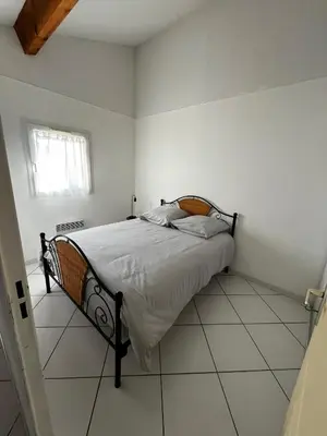 a bedroom with a bed in a white room at Maison de vacances à la mer in Port-la-Nouvelle
