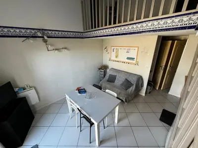 a living room with a table and a couch at Maison de vacances à la mer in Port-la-Nouvelle