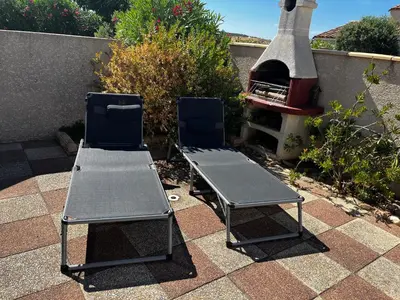 two chairs and a table and a grill at Maison de vacances à la mer in Port-la-Nouvelle