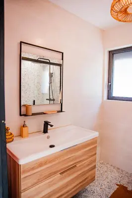 a bathroom with a sink and a mirror at Maison Nomade piscine privée, parking et clim in Carcassonne