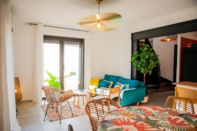 a living room with a blue couch and chairs at Maison Nomade piscine privée, parking et clim in Carcassonne