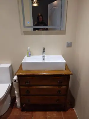 a bathroom with a sink and a person in a mirror at Maison Rose - Maison de village avec jardin privé, centre Capestang in Capestang