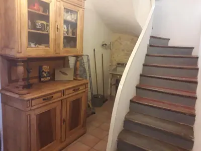 a stairway with a wooden cabinet and a staircase at Maison Rose - Maison de village avec jardin privé, centre Capestang in Capestang